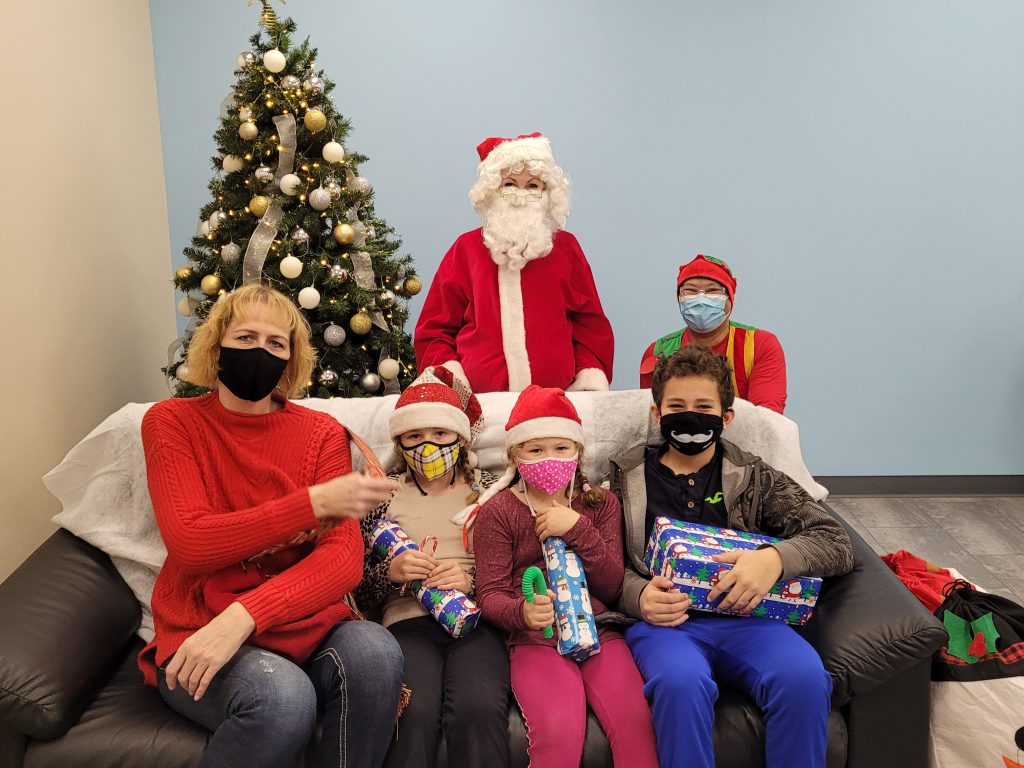 Santa, his elf, and a family of a mom and three children at Breakfast with Santa